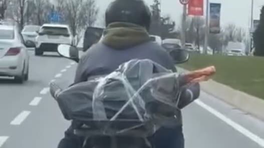 Mide bulandıran görüntü. Motorcu ayağının altında et taşıdı